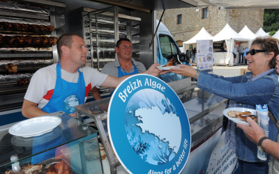 France's Aurelien Leclaire (L) of Breizh Algae Invest, and French rotisserie chef Sebastien Forestier (C) offer roasted antibiotic-free and seaweed-fed chicken to tourists in Morlaix, western France. Breizh Algae Invest, the Investment fund of marine biotechnology specialist Olmix, raises antibiotic-free and seaweed fed chickens. [Photo: ANP]